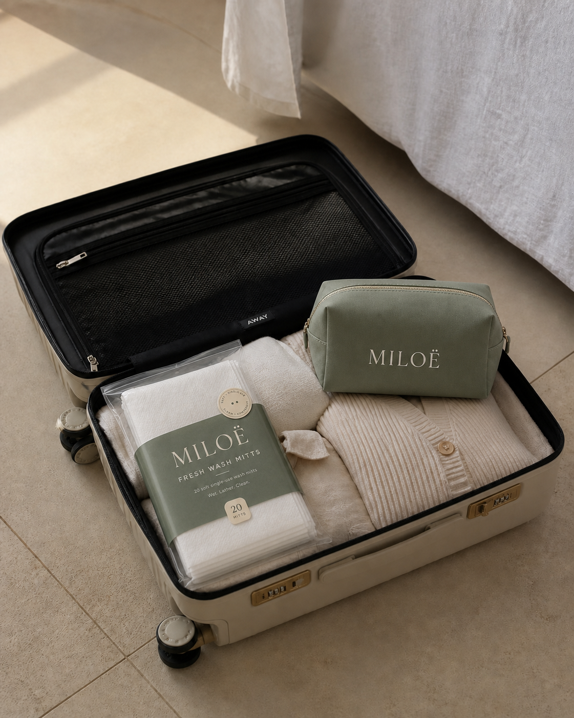 Valise ouverte avec trousse de toilette et pochette MILOË